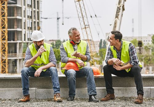 Three guys having lunch on a jobsite